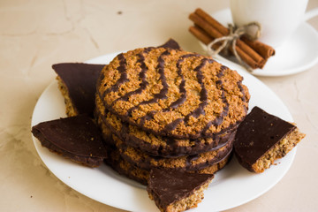 Oatmeal cookies with chocolate on a white plate. Tasty dessert.