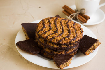 Oatmeal cookies with chocolate on a white plate. Tasty dessert.