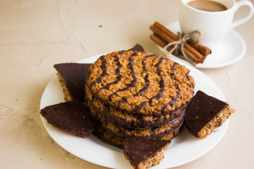 Oatmeal cookies with chocolate on a white plate. Tasty dessert.