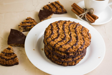 Oatmeal cookies with chocolate on a white plate. Tasty dessert.