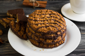 Oatmeal cookies with chocolate on a white plate. Tasty dessert.