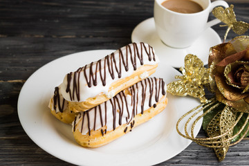 Eclairs in white glaze on a white plate. Delicious dessert.
