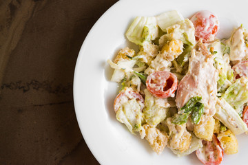 Caesar salad with chicken on a marble table