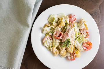 Caesar salad with chicken on a marble table