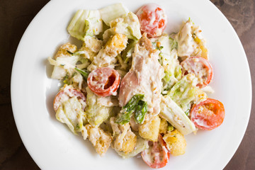 Caesar salad with chicken on a marble table