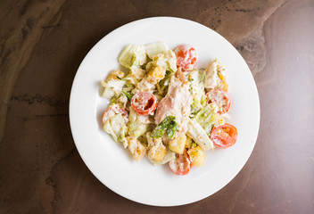 Caesar salad with chicken on a marble table