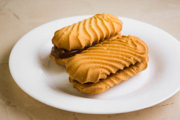 Biscuit sandwich with caramelized milk on a marble table. Tasty dessert.