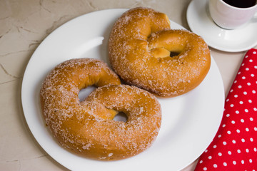 Pretzel in sugar on a marble table. Tasty dessert.