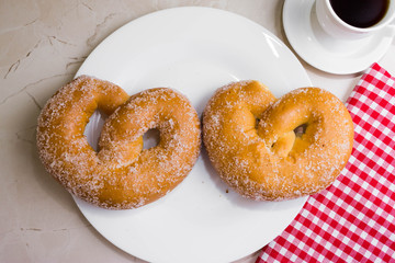 Pretzel in sugar on a marble table. Tasty dessert.