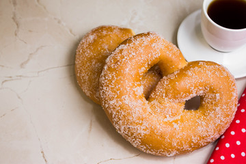 Pretzel in sugar on a marble table. Tasty dessert.