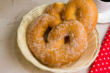 Pretzel in sugar on a marble table. Tasty dessert.