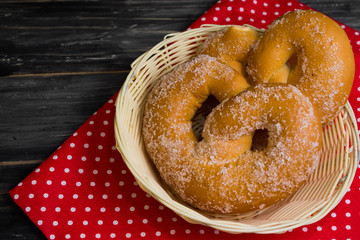 Pretzel in sugar on a wooden background in rustic style. Tasty dessert.