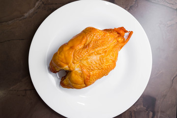 Smoked chicken breast on a marble table and ingredients. A delicious dish.