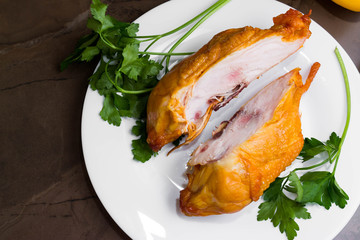 Smoked chicken breast on a marble table and ingredients. A delicious dish.