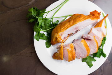 Smoked chicken breast on a marble table and ingredients. A delicious dish.