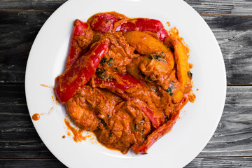 Bigus with chicken breast and bell pepper on a wooden table in rustic style