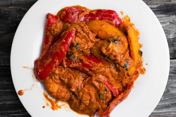 Bigus with chicken breast and bell pepper on a wooden table in rustic style