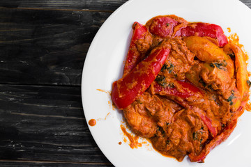 Bigus with chicken breast and bell pepper on a wooden table in rustic style
