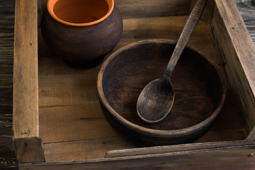 Rustic crockery in a box on a wooden table in rustic style