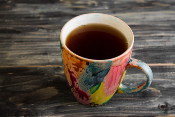 Colorful cup of tea on a wooden table in rustic style