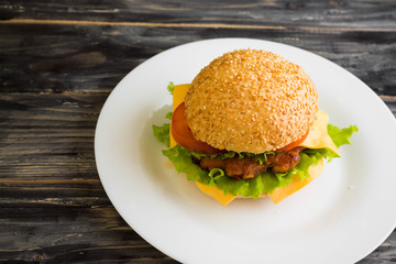 Hamburger on a wooden table in rustic style and ingredients