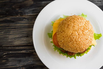 Hamburger on a wooden table in rustic style and ingredients