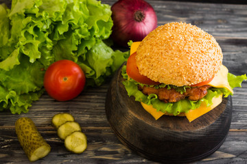Hamburger on a wooden table in rustic style and ingredients