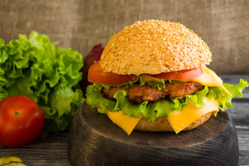 Hamburger on a wooden table in rustic style and ingredients