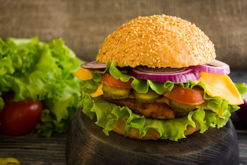 Hamburger on a wooden table in rustic style and ingredients