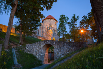Fototapeta na wymiar View of beautiful ruins of ancient Livonian castle in old town of Cesis, Latvia. Greenery and summer evening.