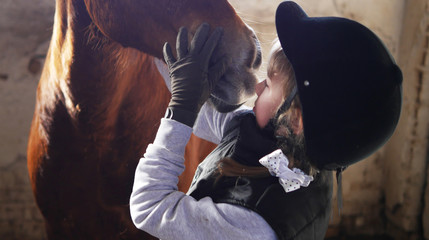 Girl hugging a horse.