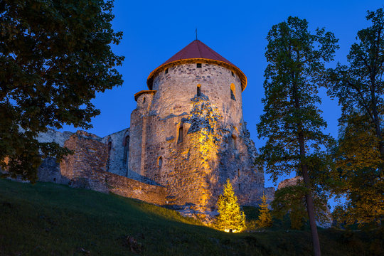 View of beautiful ruins of ancient Livonian castle in old town of Cesis, Latvia. Greenery and summer evening.