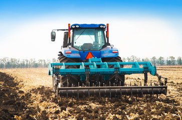 Modern tractor in the field on a sunny day.