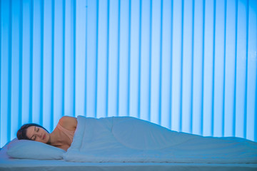 The sleeping woman lay on the bed. Evening night time