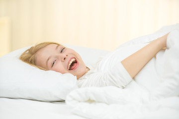 Obraz na płótnie Canvas The cute girl yawn and lay on the bed