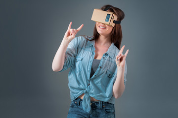 Woman using a new virtual reality headset on grey background