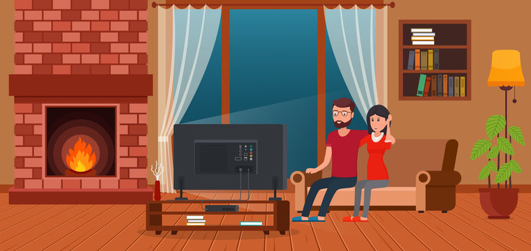 Young couple sitting on sofa watching TV by fireplace. Contemporary living room interior.