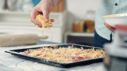 Chef hand sprinkle pizza with cheese