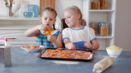 Obraz na płótnie Canvas Little girls preparing pizza from ingredients