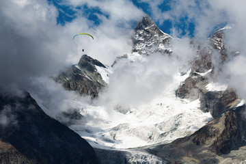 Paragliding in the Swiss Alps on a background of blue sky
