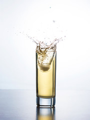 Yellow juice with splash in glass
