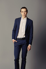 Fototapeta premium Business fashion man wearing blue suit with white shirt. Studio shot against grey
