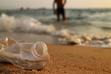 Crushed plastic water bottle on beach.