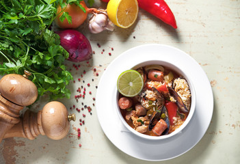 Paella in white plate with saffron rice, peas, shrimps, mussels, squid, meat. Seafood paella, traditional spanish dish. Top view