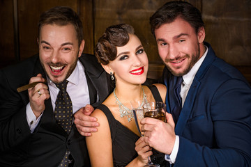 Richness, wealth, luxury concepts. Best happy friends having party in luxurious restaurant. People resting and relaxing with alcohol and cigars.