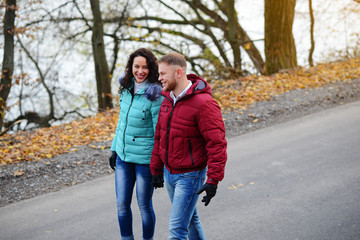 Obraz premium Lovers walking hand in hand in autumn park