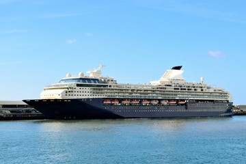 Fototapeta na wymiar Großes Kreuzfahrtschiff im Hafen vor Anker liegend - blauer Himmel im Hintergrund