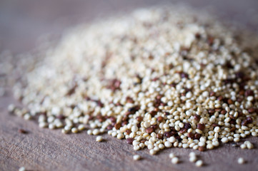 Quinoa - unusual cereal health is scattered on a wooden brown board