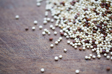 Quinoa - unusual cereal health is scattered on a wooden brown board