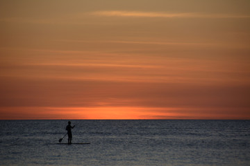 Lonely surfer at sunset over the sea, Boracay Philippines